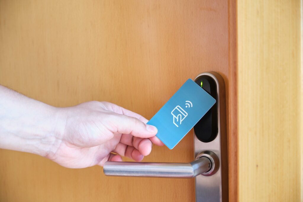 Male hand opening the hotel room electronic lock with a key card.