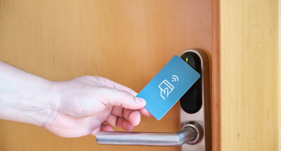 Male hand opening the hotel room electronic lock with a key card.